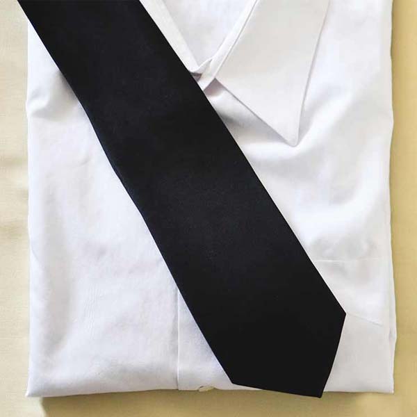 A black necktie on top of a white dress shirt