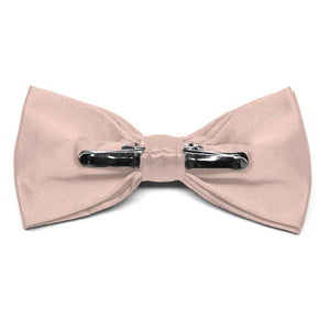 The back of a blush pink solid color clip-on bow tie, showing the two metal clips