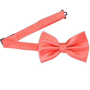 A bright coral pre-tied bow tie with the band open