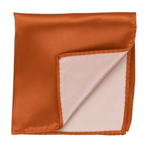 A burnt orange pocket square with a corner flipped up to show the back
