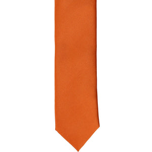 The front of a burnt orange skinny tie, laid flat