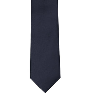 The front of a dark navy blue slim tie, laid flat