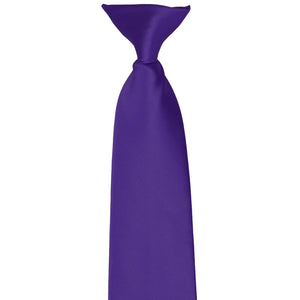The top of a knot on a dark purple clip-on tie