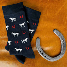 Load image into Gallery viewer, Dark navy horse and horseshoe socks displayed with a horseshoe on a leather background