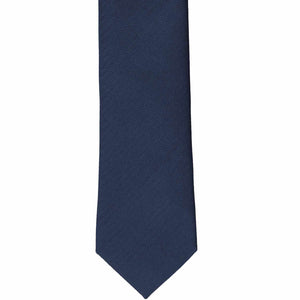 The front of a navy blue slim tie, laid out flat