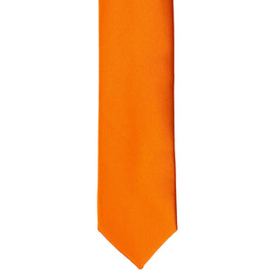 The front of an orange skinny tie, laid out flat