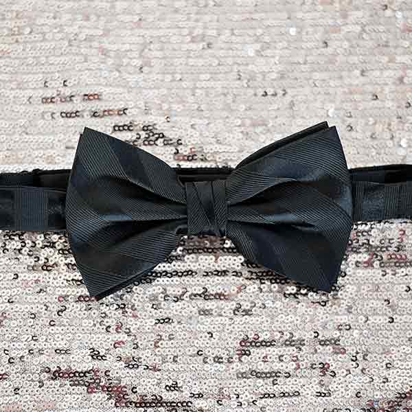 Black formal bow tie on a sequin background