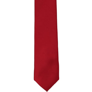 The front of a red skinny silk tie in a solid color, laid out flat