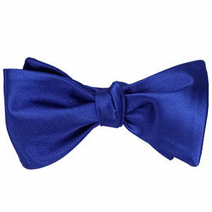 A sapphire blue self-tie bow tie, tied