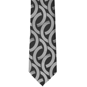 The bottom front of a slim tie in a black and gray link pattern