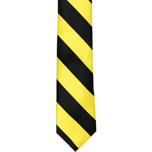The front of a black and yellow striped skinny tie, laid out flat