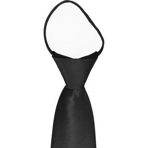 A closeup of the knot on a men's black zipper tie