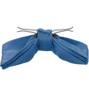The side view of a blue clip-on bow tie, opened