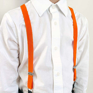 A boy wearing a white dress shirt with tangerine suspenders