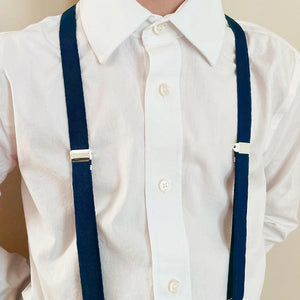 Boy wearing twilight blue suspenders with a white dress shirt