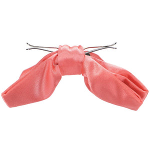 A coral clip-on bow tie, opened