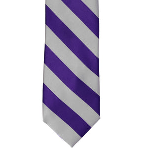 The front of a dark purple and silver striped tie