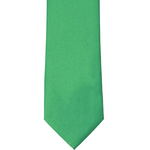 The front, bottom tip of an emerald green solid tie