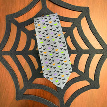 Load image into Gallery viewer, Bat novelty tie in Halloween colors on top of a spider web mat