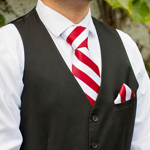 Man wearing a candy cane striped tie, pocket square with a black vest
