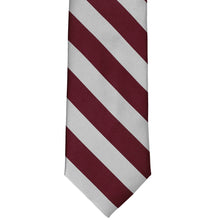 Load image into Gallery viewer, The front of a maroon and silver striped tie, laid out flat
