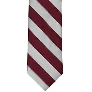 The front of a maroon and silver striped tie, laid out flat