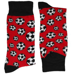 A folded pair of red socks with scattered soccer balls