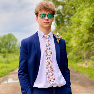 Teen wearing a floral tie with a navy blue suit for prom