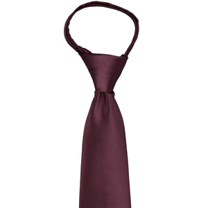 The knot and front view of a wine colored zipper tie