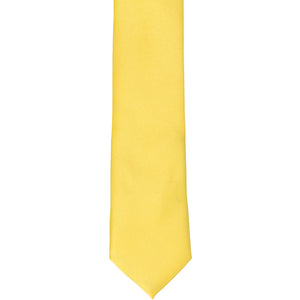 The front of a banana yellow skinny tie, laid out flat