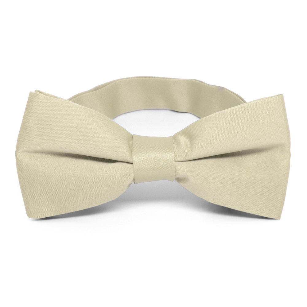 A beige solid bow tie, pre-tied with a band collar