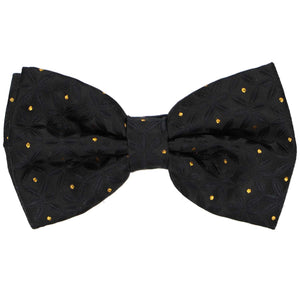 A pre-tied black bow tie with a textured tone-on-tone pattern and shimmery gold polka dots