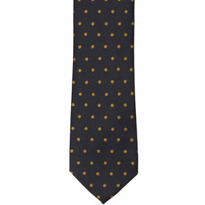 The front of a black and old gold polka dot necktie, laid out flat