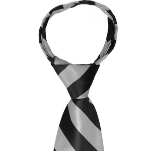 The knot on a black and silver striped zipper tie