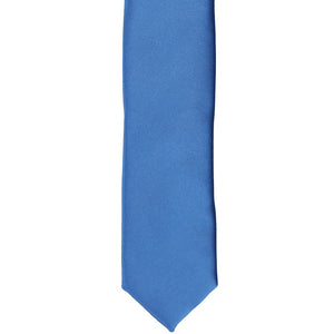 The front of a blue solid skinny tie, laid flat