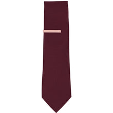 Load image into Gallery viewer, A solid blush pink tie bar on a dark burgundy necktie