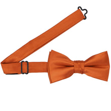 Load image into Gallery viewer, A boys&#39; pre-tied burnt orange bow tie with the band open