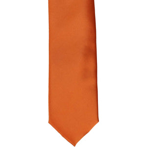 The front of a boys' burnt orange solid tie, laid out flat