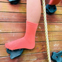 Load image into Gallery viewer, A child climbing on a swingset wearing coral socks