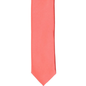 The front of a bright coral skinny tie, laid flat