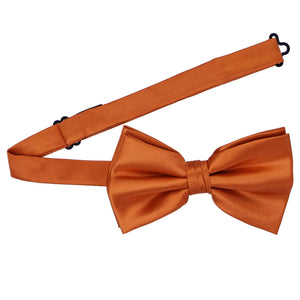 A burnt orange pre-tied bow tie with the band collar open