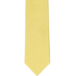 The front of a butter yellow herringbone tone-on-tone slim tie