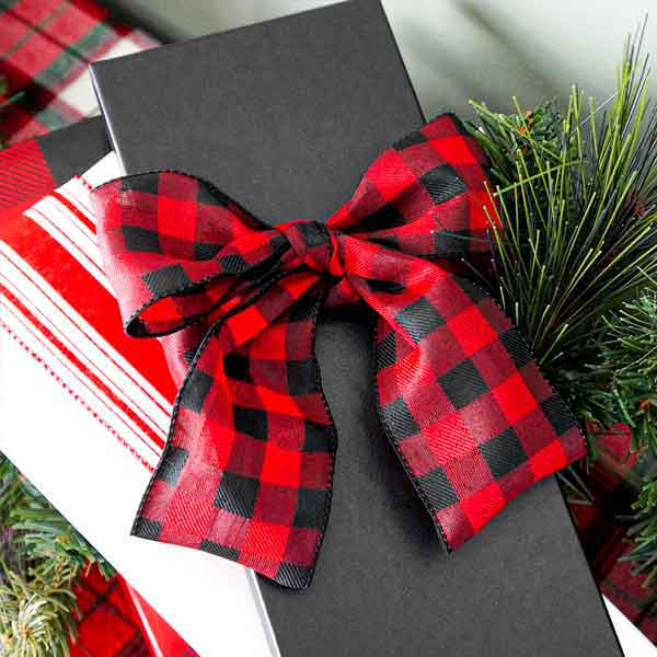 A black tie box with a Christmas plaid ribbon