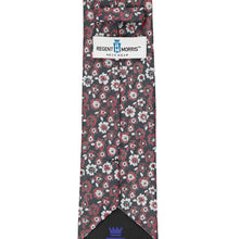 Load image into Gallery viewer, A necktie with a dark gray base and a dense floral pattern in crimson red and white, featuring a white Regent Morris Neckwear label.