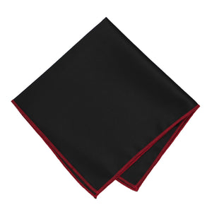 A black pocket square with crimson tipping, folded into a diamond