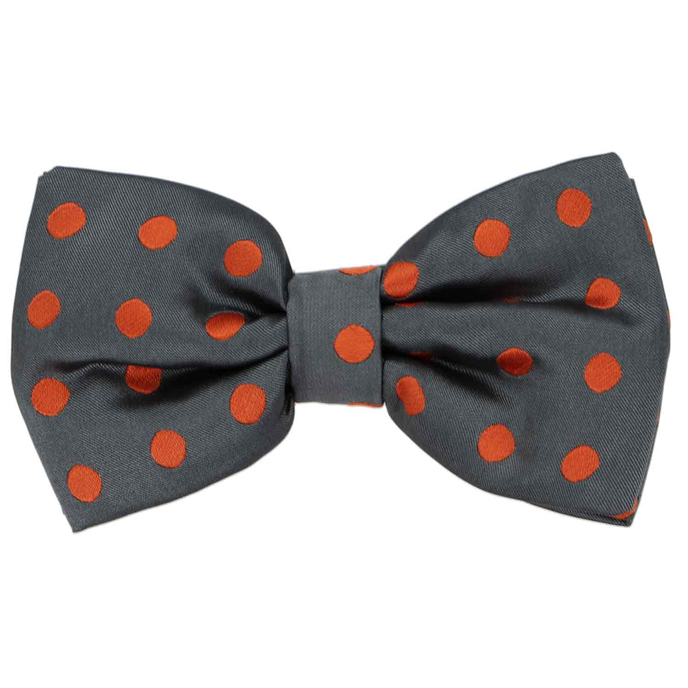 This dark gray pre-tied bow tie features burnt orange polka dots