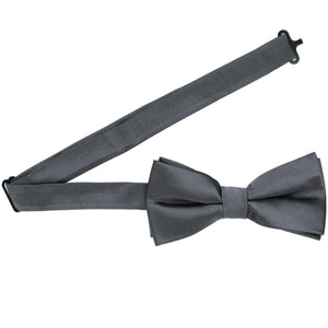 A dark gray pre-tied bow tie with the band collar open