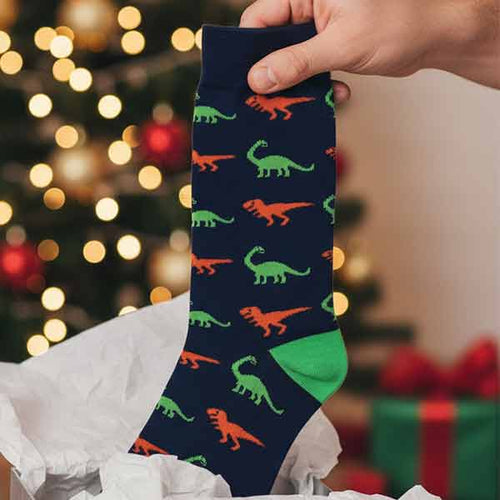 Man pulling dinosaur themed socks out of a gift box