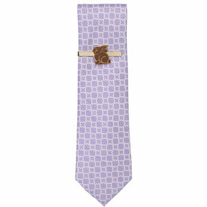 A chocolate Easter bunny tie bar in brown and gold on a purple patterned necktie