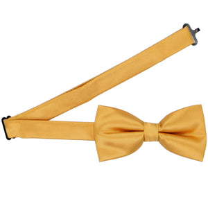 A pre-tied gold bar bow tie with the band collar open